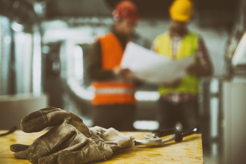 Construction glove with two workers in background | Shine Lawyers